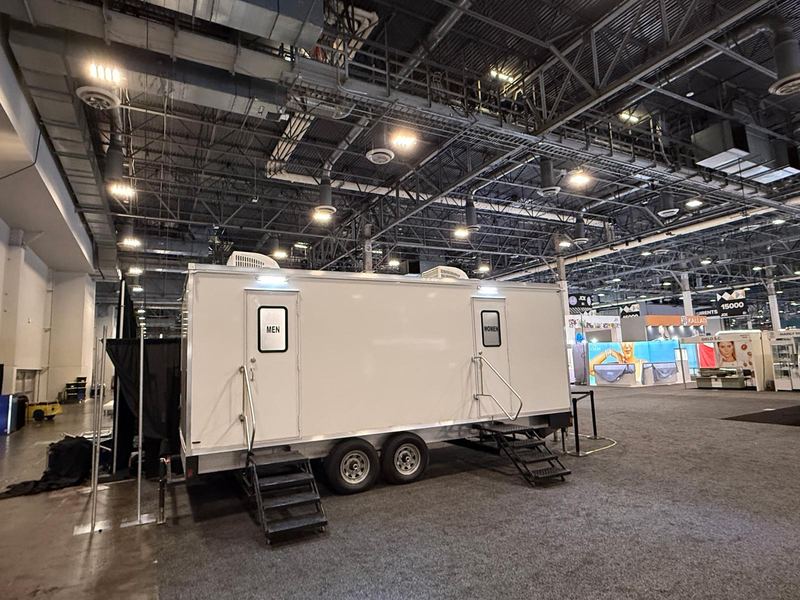 Restroom trailer set up inside an expo hall for a trade show