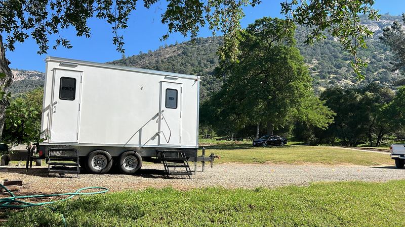 Restroom trailer parked on a lawn in a park